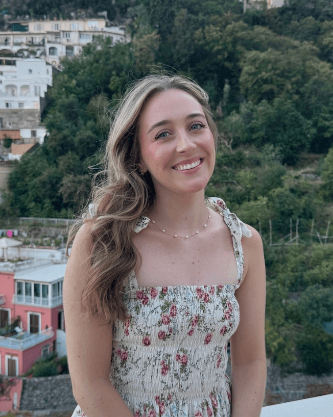 Kelsey smiling in a floral dress while traveling in Italy